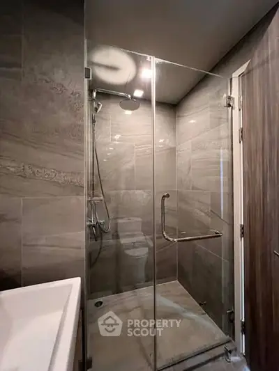 Modern bathroom with sleek glass shower enclosure and elegant tile design.