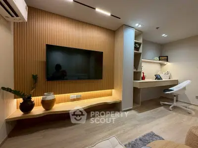 Modern living room with stylish TV setup and cozy study area, featuring elegant wood paneling and ambient lighting.