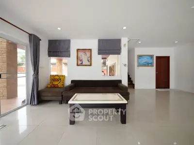 Spacious modern living room with stylish decor and large windows for natural light.