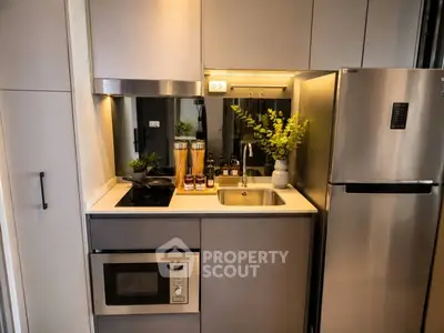Modern compact kitchen with stainless steel appliances and sleek cabinetry