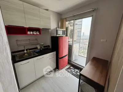 Modern compact kitchen with balcony view in urban apartment