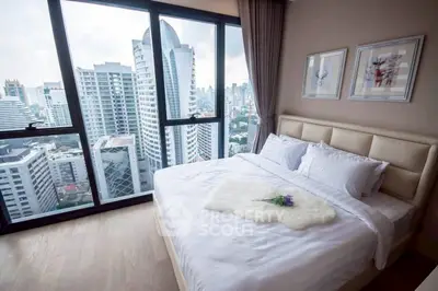 Luxurious bedroom with stunning city view from floor-to-ceiling windows in high-rise apartment.