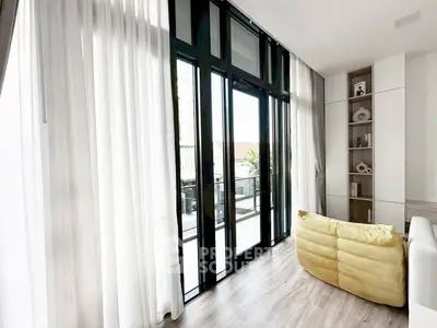 Modern living room with floor-to-ceiling windows and balcony access