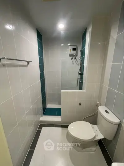 Modern bathroom with sleek tiles and walk-in shower in a contemporary apartment.