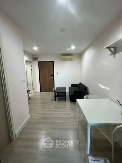 Modern living room with sleek furniture and wooden flooring in a cozy apartment.