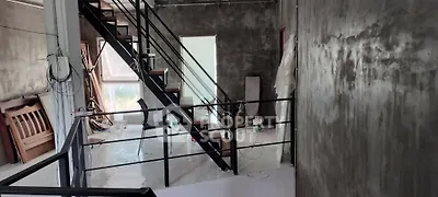Industrial-style interior with exposed concrete walls and metal staircase, perfect for modern loft living.