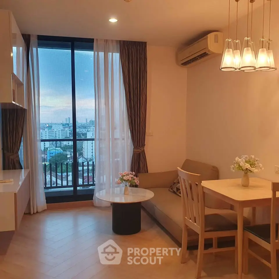 Cozy living room with city view, featuring modern furniture and elegant lighting.