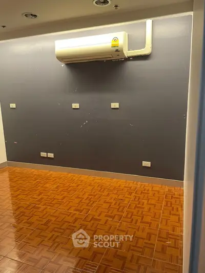 Spacious room with parquet flooring and wall-mounted air conditioning unit.
