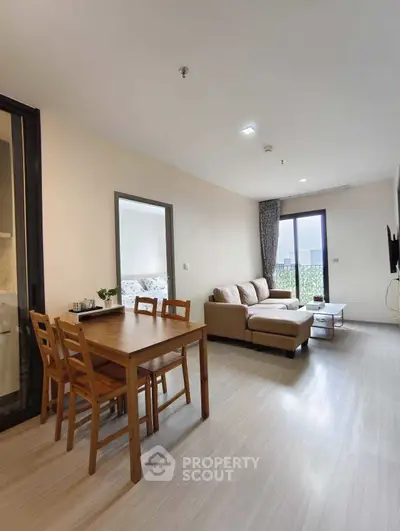 Modern living room with cozy sofa and dining area in open layout apartment.