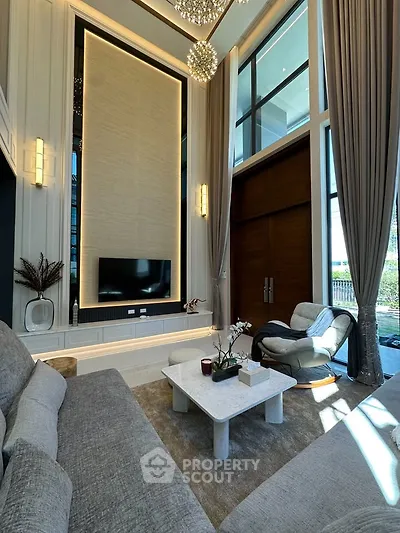 Luxurious high-ceiling living room with elegant decor and large windows