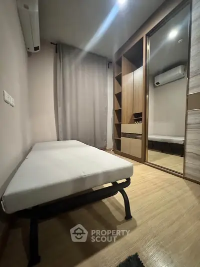 Cozy minimalist bedroom with mirrored wardrobe and air conditioning.