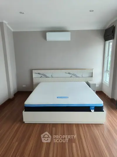 Spacious bedroom with modern design and large window for natural light