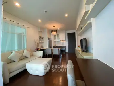 Modern living room with elegant decor and open layout, featuring cozy seating and stylish lighting.