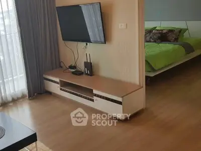 Modern living room with wall-mounted TV and view into stylish bedroom