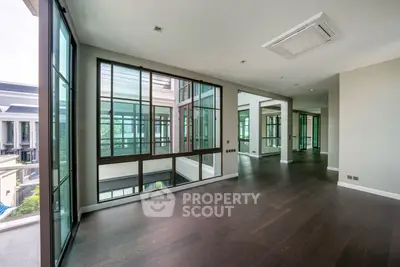 Spacious modern living room with large windows and hardwood floors