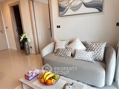 Modern living room with stylish sofa and decorative pillows, featuring elegant wall art and fresh fruit centerpiece.
