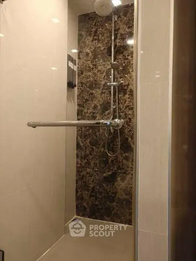 Modern bathroom shower with sleek design and marble accent wall