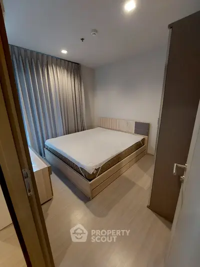 Modern bedroom with sleek design and natural light from large window.