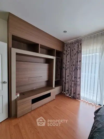 Modern living room with stylish wooden entertainment unit and elegant curtains