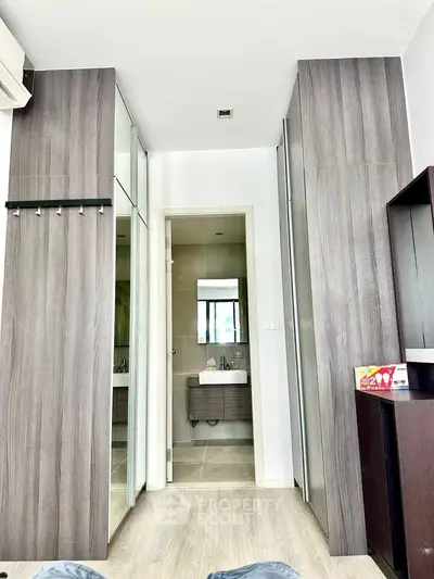 Modern bedroom with ensuite bathroom and sleek wood paneling