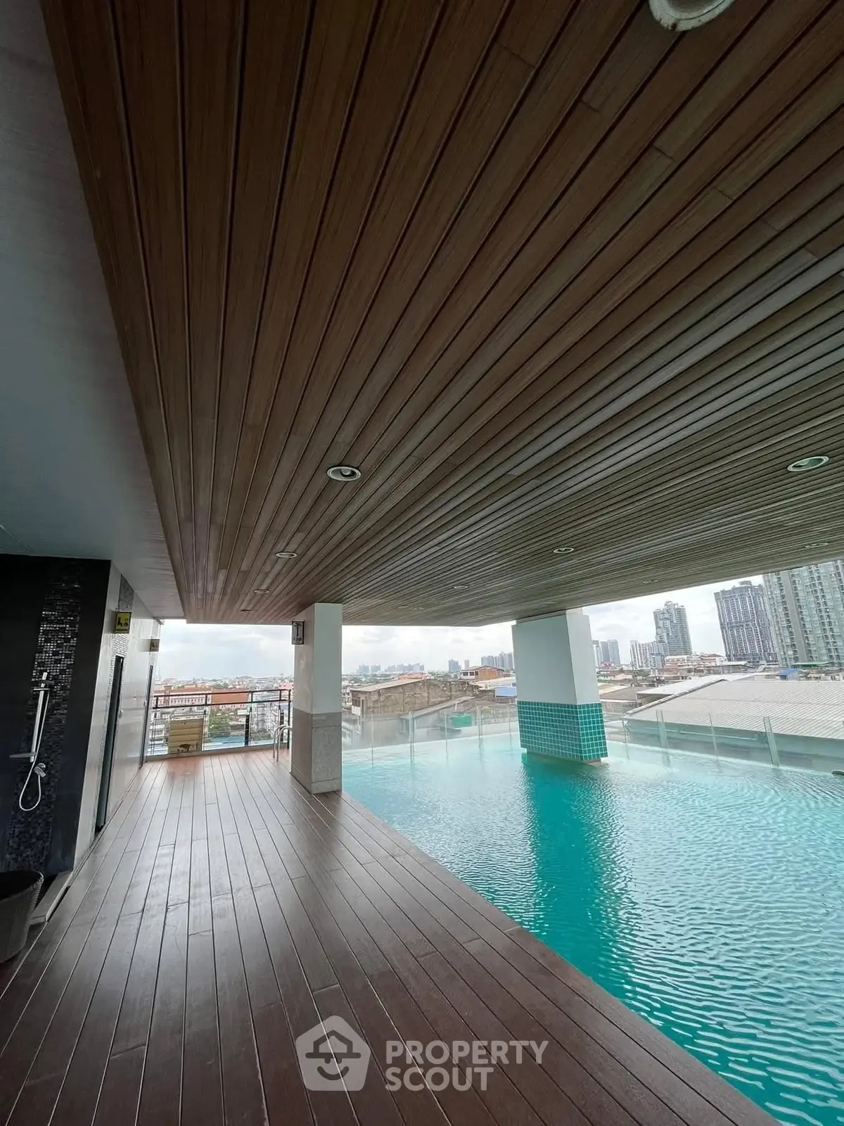 Luxurious rooftop pool with stunning city views and modern wooden deck.