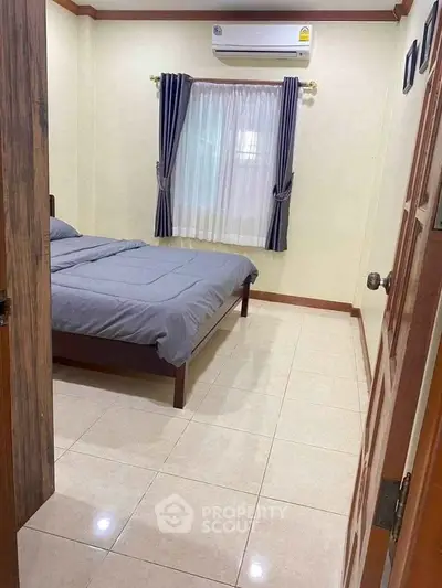 Cozy bedroom with air conditioning and elegant curtains, perfect for a restful retreat.