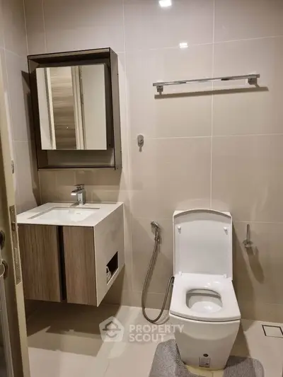 Modern bathroom with sleek fixtures and elegant design, featuring a stylish vanity and contemporary toilet.