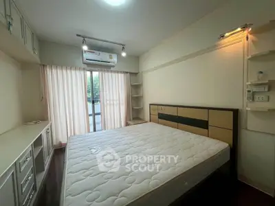 Spacious bedroom with large window and modern furnishings, perfect for comfort and relaxation.