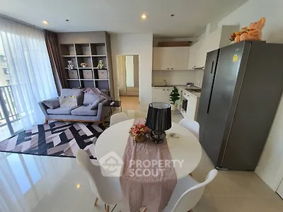Modern open-plan living room with stylish decor and kitchen area