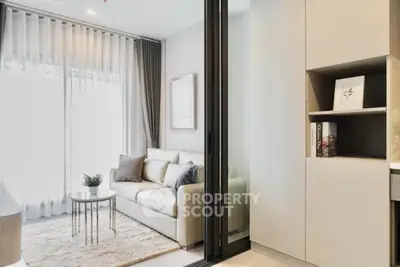 Modern living room with elegant decor and natural light, featuring a cozy sofa and stylish shelving.