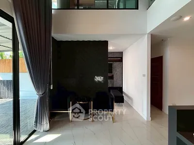 Modern living room with high ceilings and elegant decor, featuring large windows and luxurious curtains.