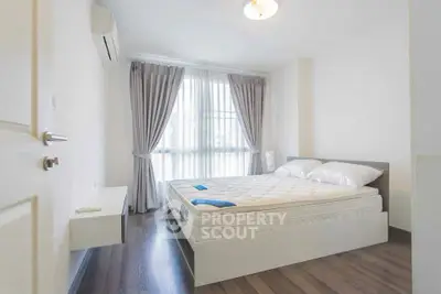 Bright and airy bedroom with modern decor and large window for natural light.