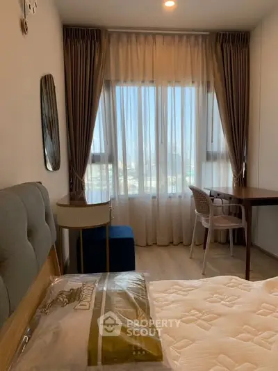 Cozy bedroom with elegant curtains and a study desk by the window, perfect for relaxation and work.