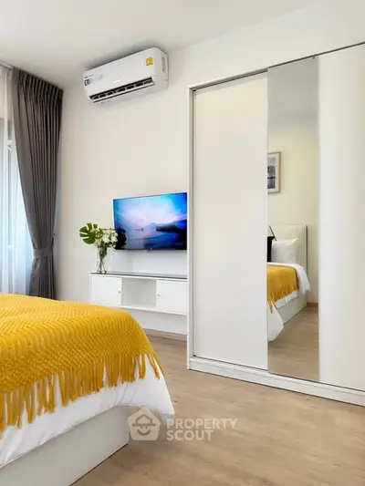 Modern bedroom with mirrored closet and stylish decor