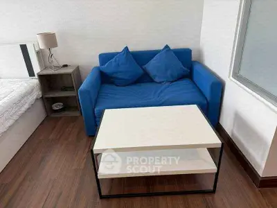 Cozy bedroom with blue sofa and modern coffee table