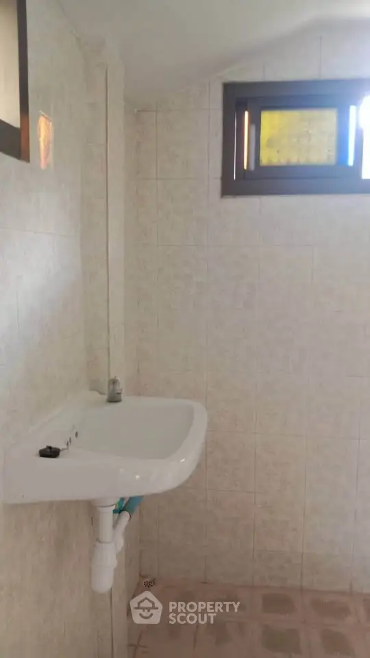 Simple bathroom with wall-mounted sink and small window