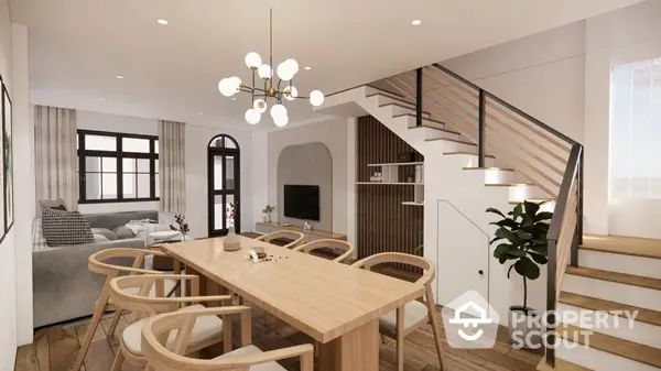 Elegant dining space with modern chandelier, adjacent to a cozy living area and a stylish staircase, featuring natural wood tones and chic decor.