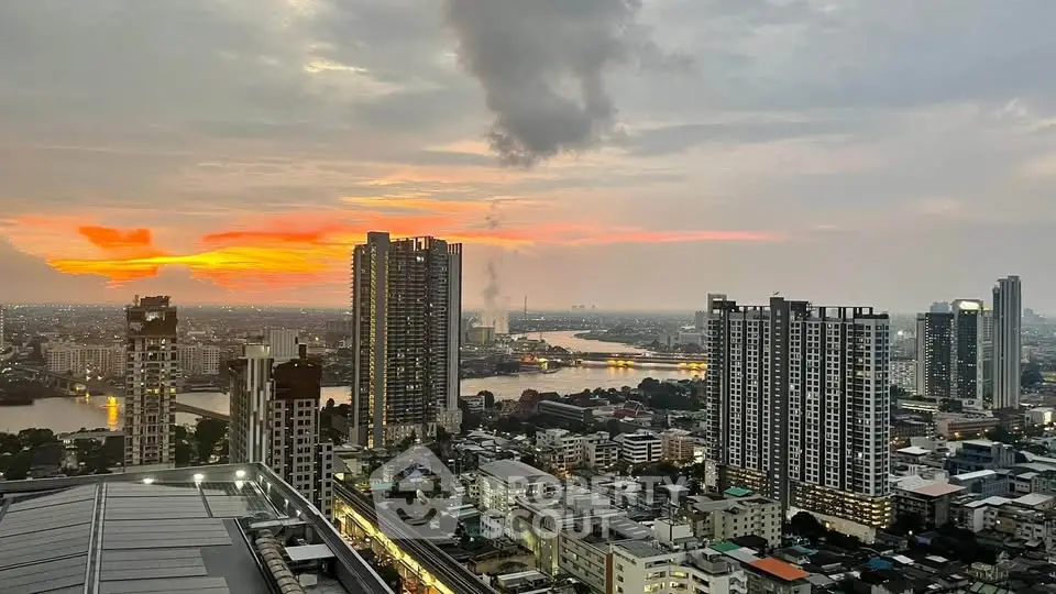 Stunning cityscape view from high-rise building at sunset, showcasing vibrant skyline and river.