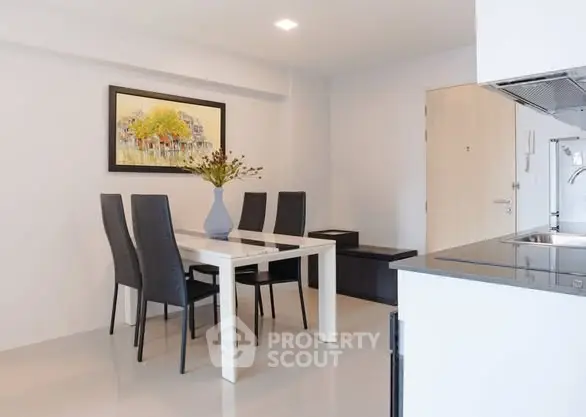Modern dining area with sleek table and chairs, open kitchen layout, and stylish decor.