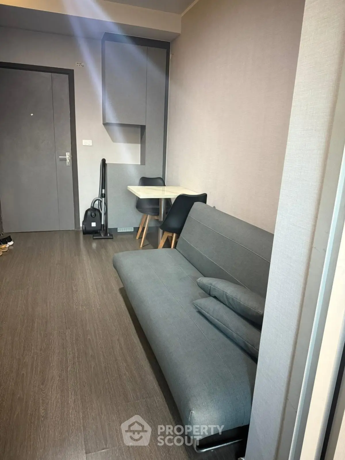 Modern living room with sleek gray sofa and compact dining area