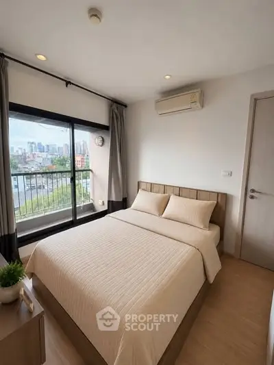 Modern bedroom with city view, featuring a cozy bed and air conditioning, perfect for urban living.