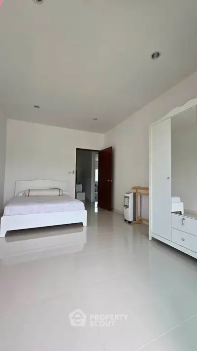 Spacious minimalist bedroom with white furniture and glossy tiled floor