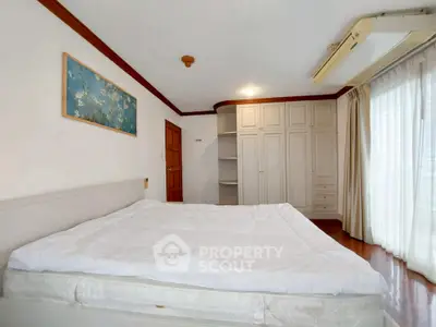 Spacious bedroom with large window and built-in wardrobe