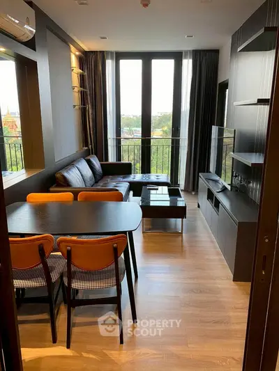 Modern living room with sleek furniture and large windows offering a scenic view.
