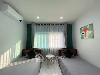Charming bedroom with twin beds, modern decor, and natural light.