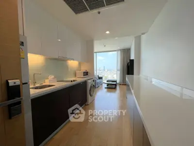 Modern kitchen with open layout and city view, featuring sleek appliances and wooden flooring.
