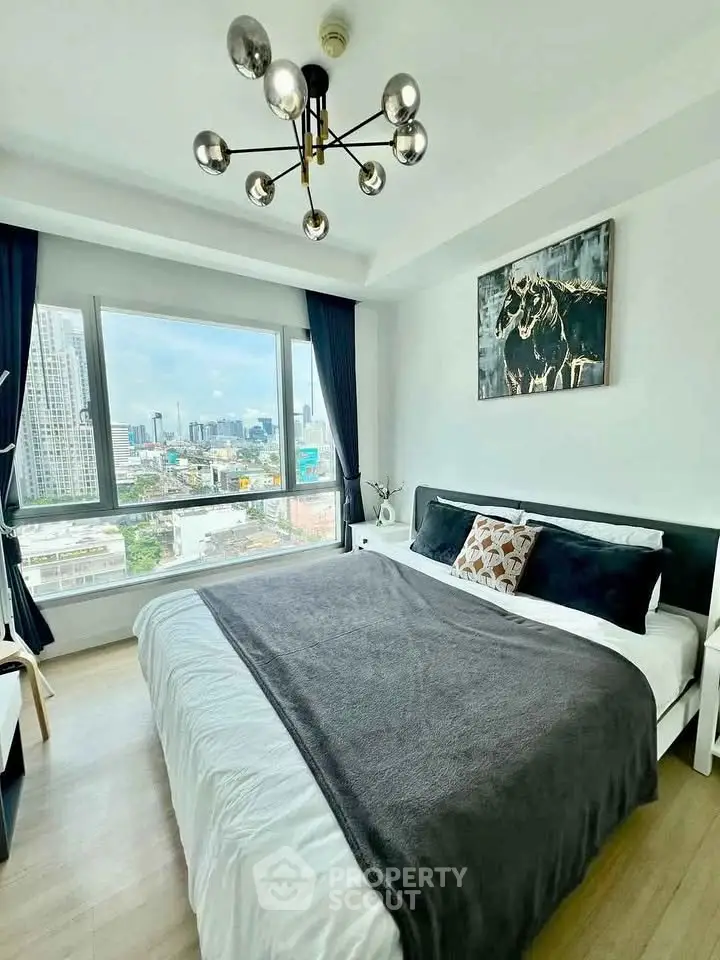 Modern bedroom with city view, stylish decor, and large window for natural light.