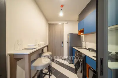 Modern compact kitchen with sleek appliances and stylish bar seating