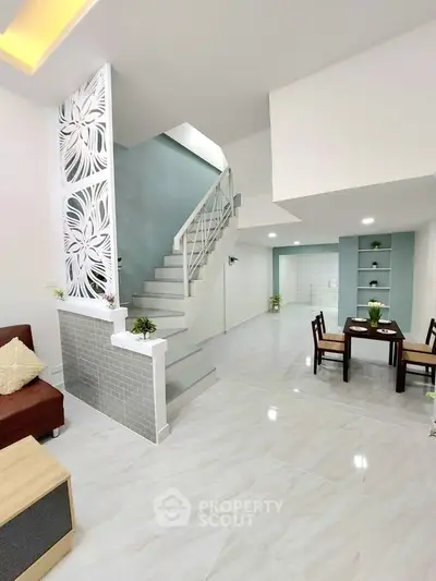 Spacious modern living area with elegant staircase and dining space, perfect for family gatherings.
