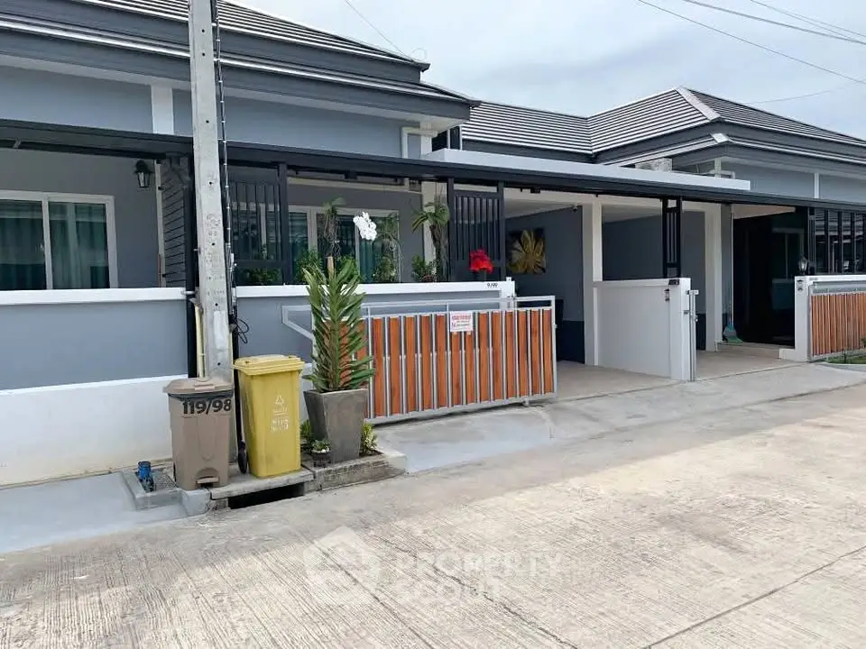 Modern townhouse exterior with driveway and garden in a suburban neighborhood.